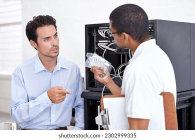 Server room, it support and wires with an engineer talking to a business man about hardware or cable replacement. Network, database and spare parts with a technician explaining information technology