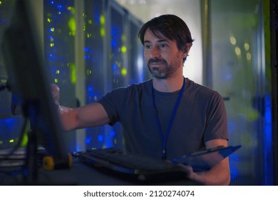 Server room technician working at computer