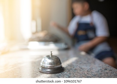 Service bell on granite table with blurry kid chef grill shrimp. - Shutterstock ID 1096101767