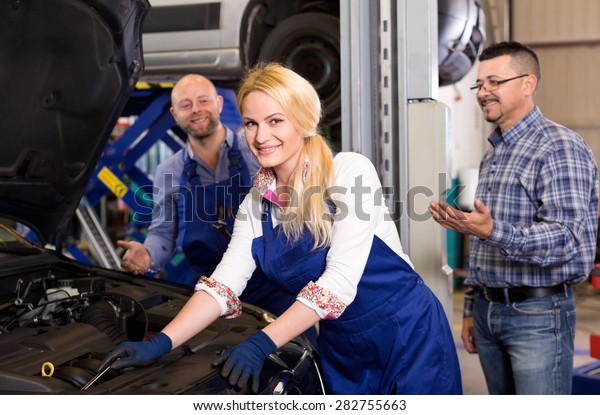 Service crew\
and cheerful client standing near\
car
