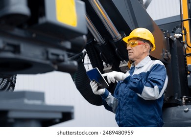 Service diagnostics and repair of hydraulic systems and hoses for industrial truck. Engineer worker uses computer tablet to configure equipment. - Powered by Shutterstock