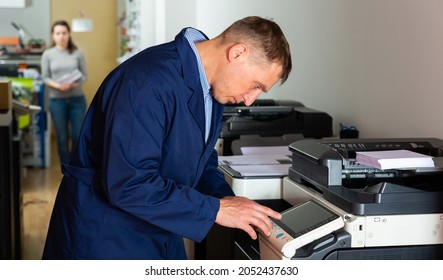 Service engineer pulls the paper from the machine. High quality photo