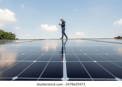 Service Engineer use tablet working inspection installation solar cell on the roof. Technician maintenance solar cells on roof factory. Technology solar energy renewable.