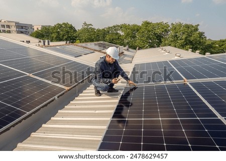 Service Engineer use tablet working inspection installation solar cell on the roof. Technician maintenance solar cells on roof factory. Technology solar energy renewable.