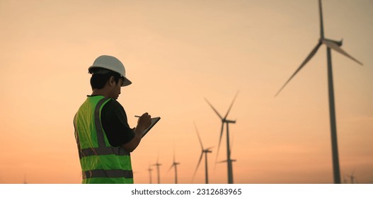 Service engineers checking system of windmill with tablet. Wind turbines generate electricity. Clean and Renewable energy concept. - Powered by Shutterstock