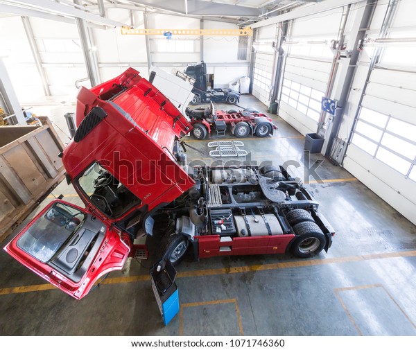 Service maintenance and repair of trucks in a\
large garage. Tippers and trucks in the hangar. Cargo\
transportation and\
logistics
