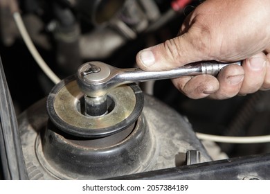 Service Man Hand Unscrews The Shock Absorber Nut With Wrench Closeup Under Cap Hood -   Car Suspension Strut Repair Maintenance