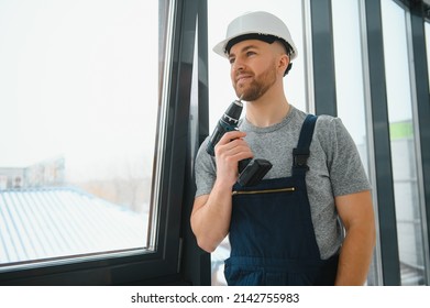 service man installing window with screwdriver - Shutterstock ID 2142755983