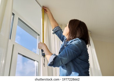 Service For Sewing And Hanging Curtains. Woman With Tape Measure Measuring Window