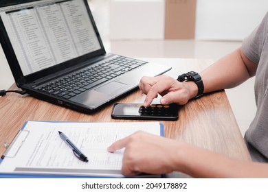 Service staff use smartphone calculate cost of repairing the car from the damage assessment document and use laptop on table office service center