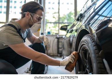 Service Station Worker Polishing The Auto Tire