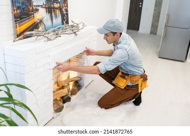 Service Technician Repairing A Fireplace In A Home