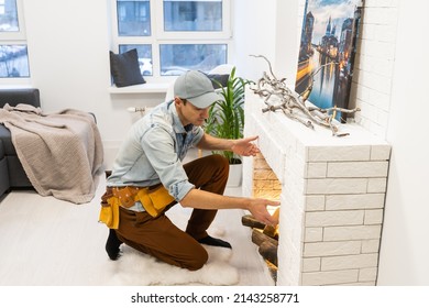 Service Technician Repairing A Fireplace In A Home