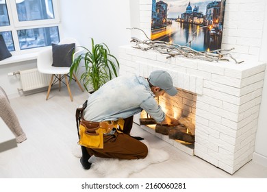 Service Technician Repairing A Fireplace In A Home