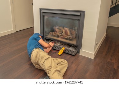 Service Technician Working On A Gas Fireplace Inside Of A Residential Home