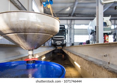 Service Of Trucks. Oil Change In Service Center. Waste Oil Drain System On A Blurred Truck Background