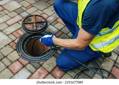 service worker cleaning blocked sewer line with hydro jetting - Shutterstock ID 2191677089