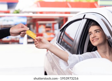 Service Worker Refuelling Car At Gas Station. Woman Customer Paying By Credit Card With Happy And Smile. Refuelling Car And Service Payment With Wireless Bank Payment Terminal Concept