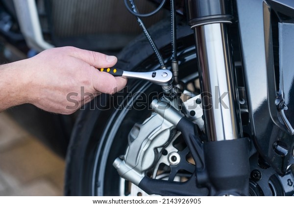 A service worker repairing a motorcycle at the\
service center