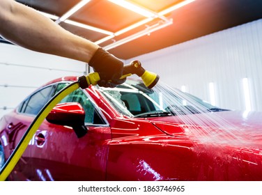 Service worker washing car on a car wash. - Shutterstock ID 1863746965
