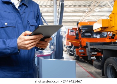 Serviceman with digital tablet on the background of the truck in the garage - Powered by Shutterstock