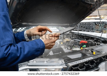Serviceman with digital tablet on the background of the car in the car service	