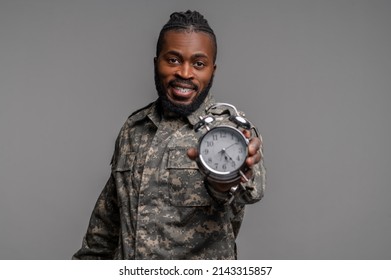 Serviceman in a khaki uniform demonstrating a timepiece