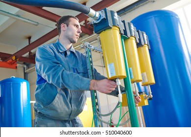 serviceman operating industrial water purification or filtration equipment