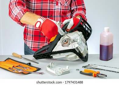 Serviceman is repairing a chainsaw  in repair shop. Repair and maintenance of chainsaws. - Powered by Shutterstock