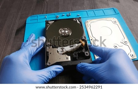 Serviceman repairs hdd data disk in service center