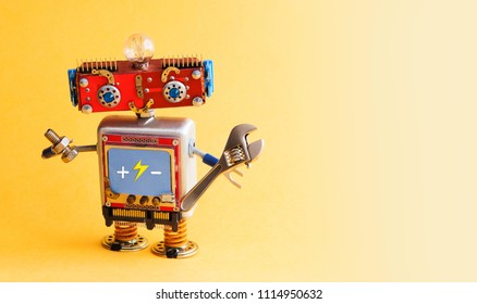 Serviceman robot ready with adjustable spanner. Creative design mechanic toy on yellow background. copy space.