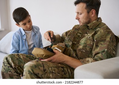 Serviceman Showing Kid How Shears Cut During Medical Operation