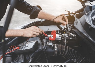 Services Car Engine Machine Concept, Automobile Mechanic Repairman Hands Checking A Car Engine Automotive Workshop With Digital Multimeter Testing Battery, Car Service And Maintenance.