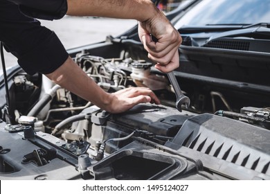 Services car engine machine concept, Automobile mechanic repairman hands repairing a car engine automotive workshop with a wrench, car service and maintenance.