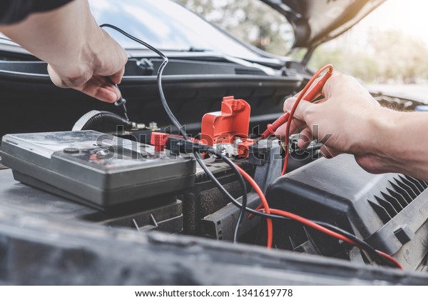 Services
car engine machine concept, Automobile mechanic repairman hands
checking a car engine automotive workshop with digital multimeter
testing battery, car service and
maintenance.