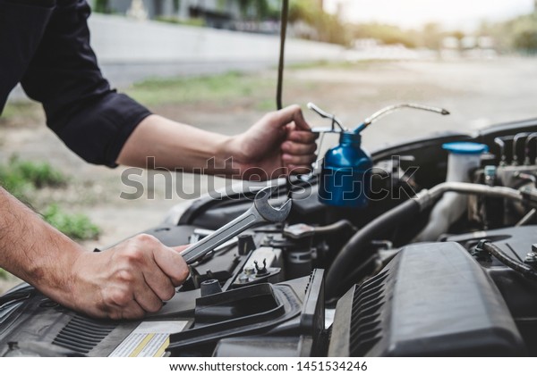 Services car
engine machine concept, Automobile mechanic repairman hands
repairing a car engine automotive workshop with a wrench and
pouring oil, car service and
maintenance.