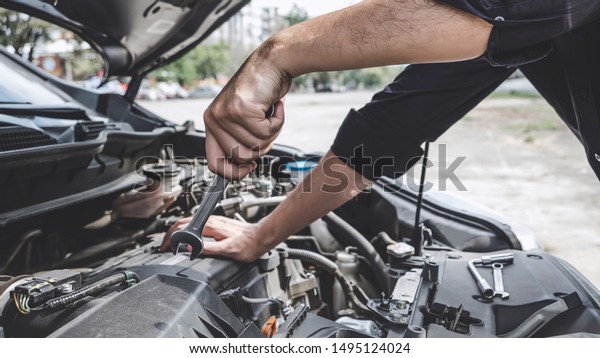 Services car engine machine
concept, Automobile mechanic repairman hands repairing a car engine
automotive workshop with a wrench, car service and
maintenance.