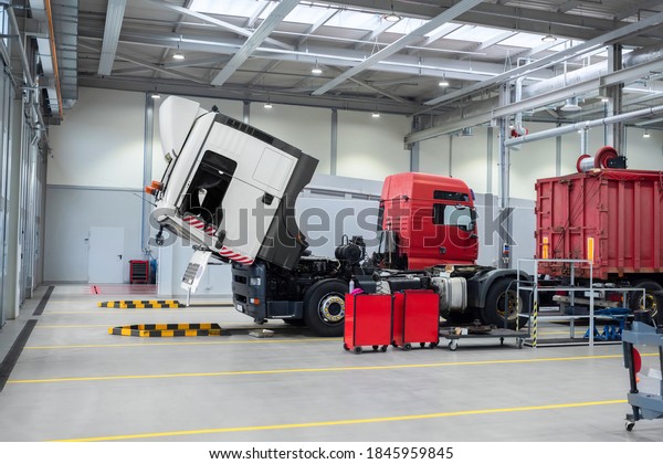 Servicing and repairing trucks in a large garage.\
Car service and truck maintenance. Auto mechanic checking the truck\
in the garage.