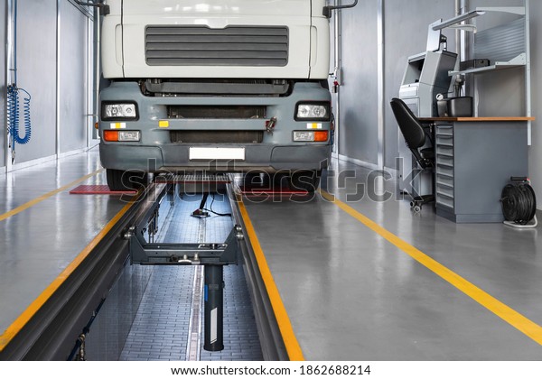 Servicing trucks in a car service. Service\
truck in a large garage. Dump trucks and trucks in the hangar.\
Cargo transportation and\
logistics