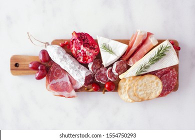 Serving board of assorted meats, cheeses and appetizers. Top view on a white marble background. - Powered by Shutterstock