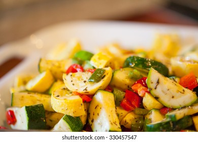 Serving bowl with herbed zucchini and yellow squash with sweet peppers