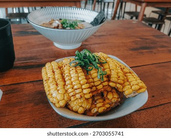 A serving of crispy corn ribs presented in a small bowl on a tabletop, showcasing a modern and flavorful snack dish