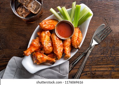 A serving of delicious spicy buffalo chicken wings on a pub style restaurant table top.