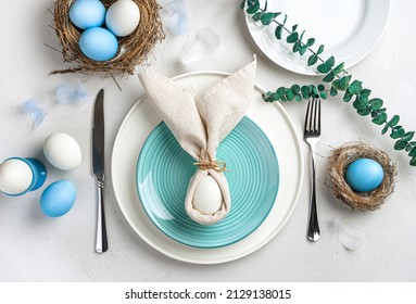 Serving of the Easter holiday table. Easter bunny made of eggs and napkins on a plate.