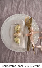 Serving a festive table for Easter.Little eggs on a white plate, top view. Festive table,top view.