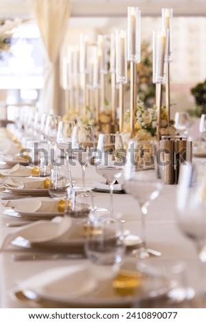 Serving the festive table at a wedding event. Decorating the wedding table with bouquets of flowers. Cutlery at a party