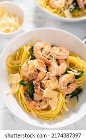 Serving Garlic Shrimp Pasta With Spinach In White Ceramic Bowls.