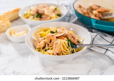 Serving Garlic Shrimp Pasta With Spinach In White Ceramic Bowls.