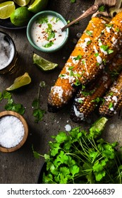 Serving Grilled Corn Cob With Fresh Herbs,lime,beer At Picnic, Top Down Table View.