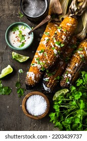 Serving Grilled Corn Cob With Fresh Herbs,lime,beer At Picnic, Top Down Table View.